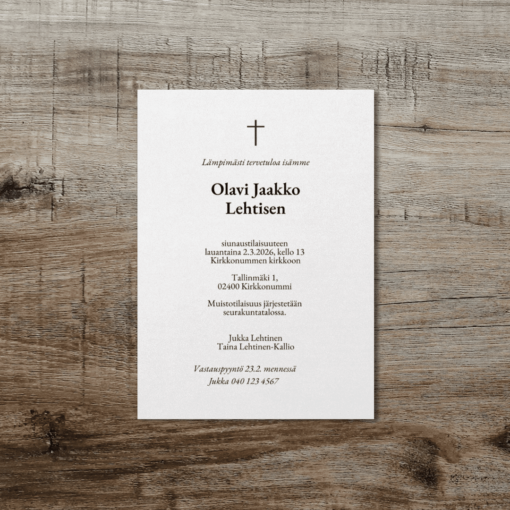 Suoralinjainen hautajaiskutsu vaalealla pohjalla, musta risti ja teksti, aseteltu ruskealle puupinnalle.