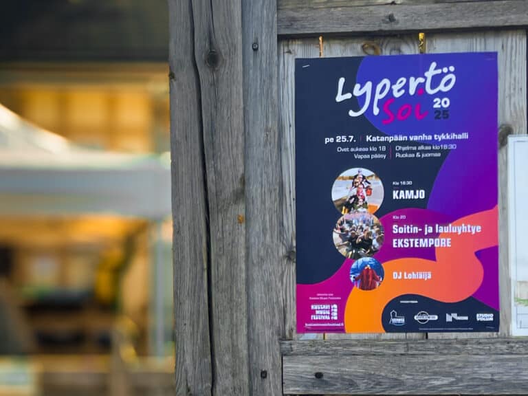 Lypertö Soi 2025 -tapahtuman ohjelmajuliste puuseinällä.