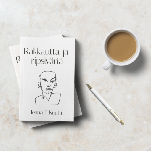 Pehmeäkantinen liimasidottu kirja nimeltä Rakkautta ja ripsiväriä vaalealla marmoripöydällä kahvikupin, kynän ja toisen kirjan kanssa.