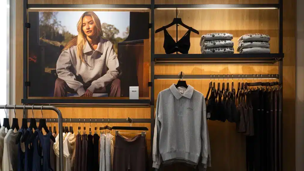 ICIW-myymälän seinällä suuri mallikuva ja sen vieressä esillä treenivaatteita ja asusteita.