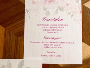 Kukkakuvioinen rippijuhlakutsu, jossa vaaleat kukkakuviot ja pinkki teksti.