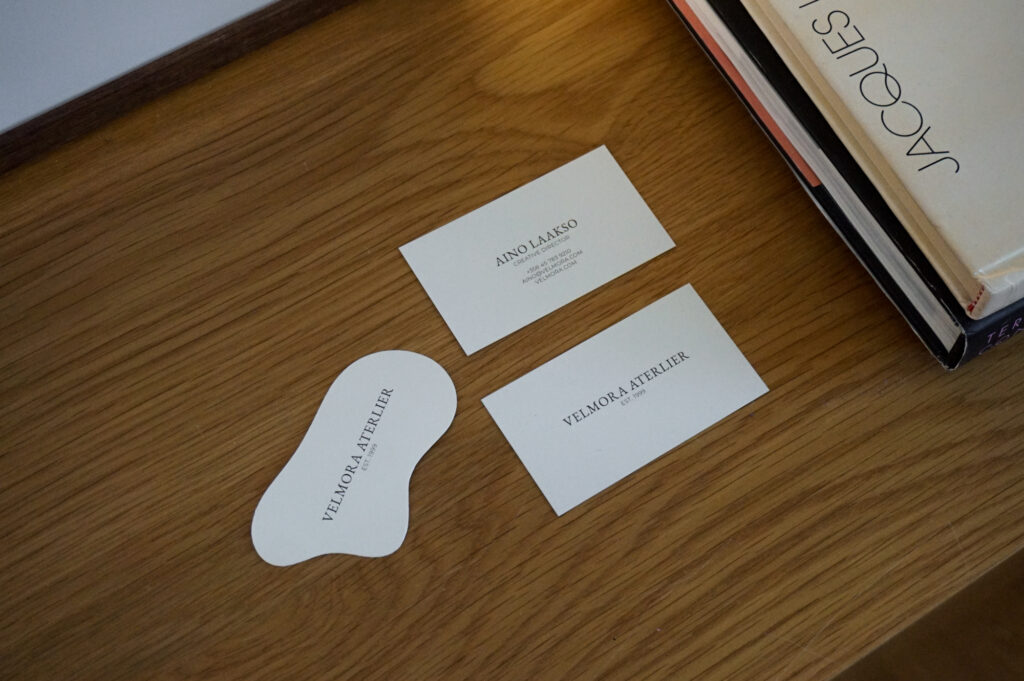 Velmora Atelier -käyntikortit, joista yksi erikoismuotoinen